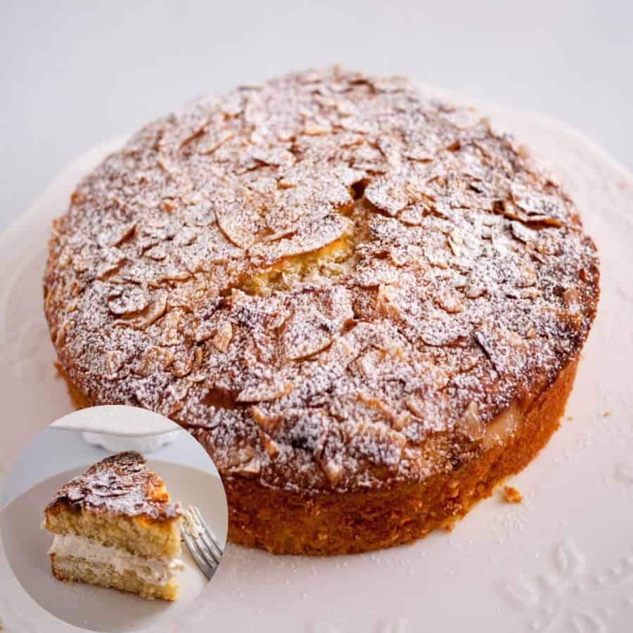 A coconut cake on a table dusted with powdered sugar.