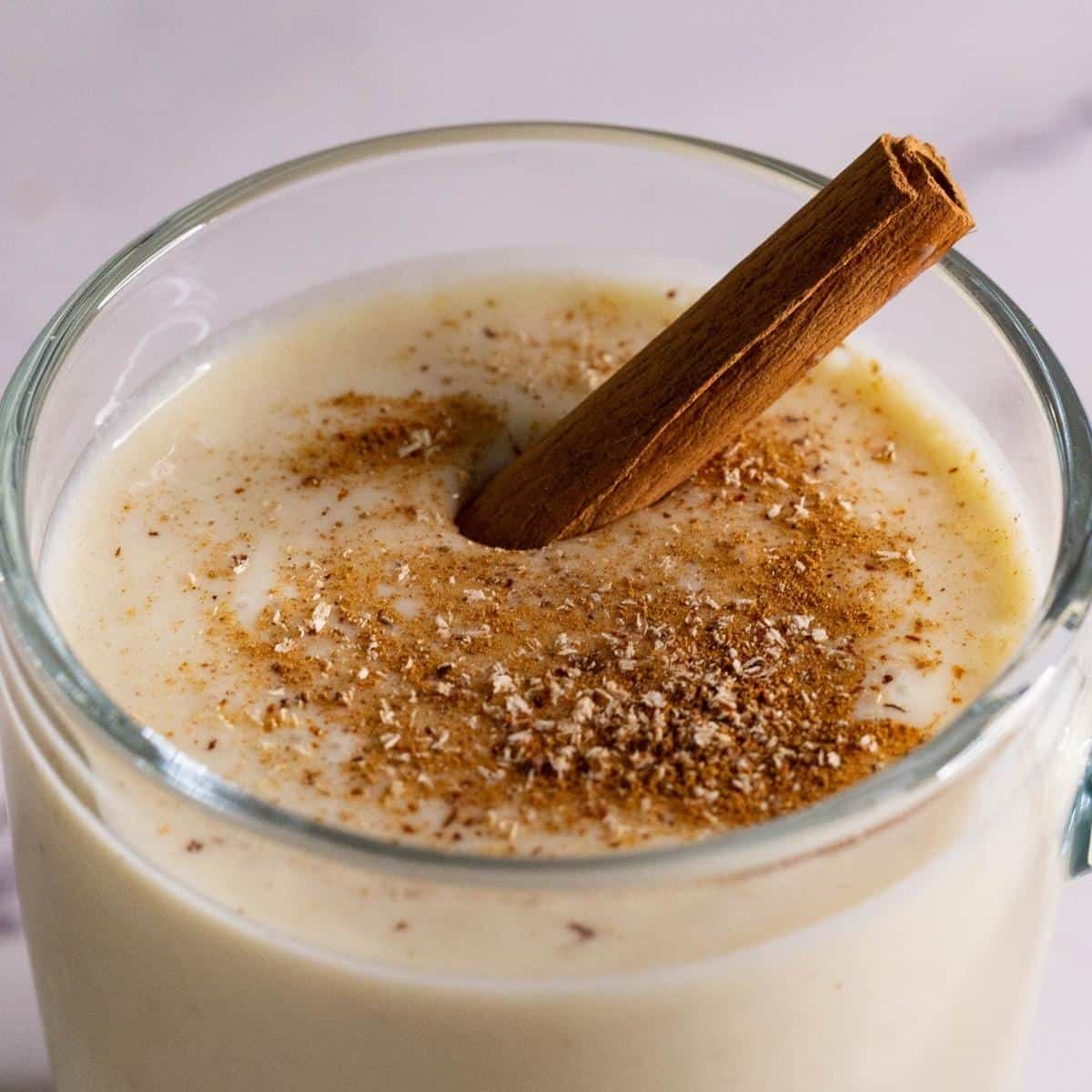 A glass with eggnog and cinnamon.