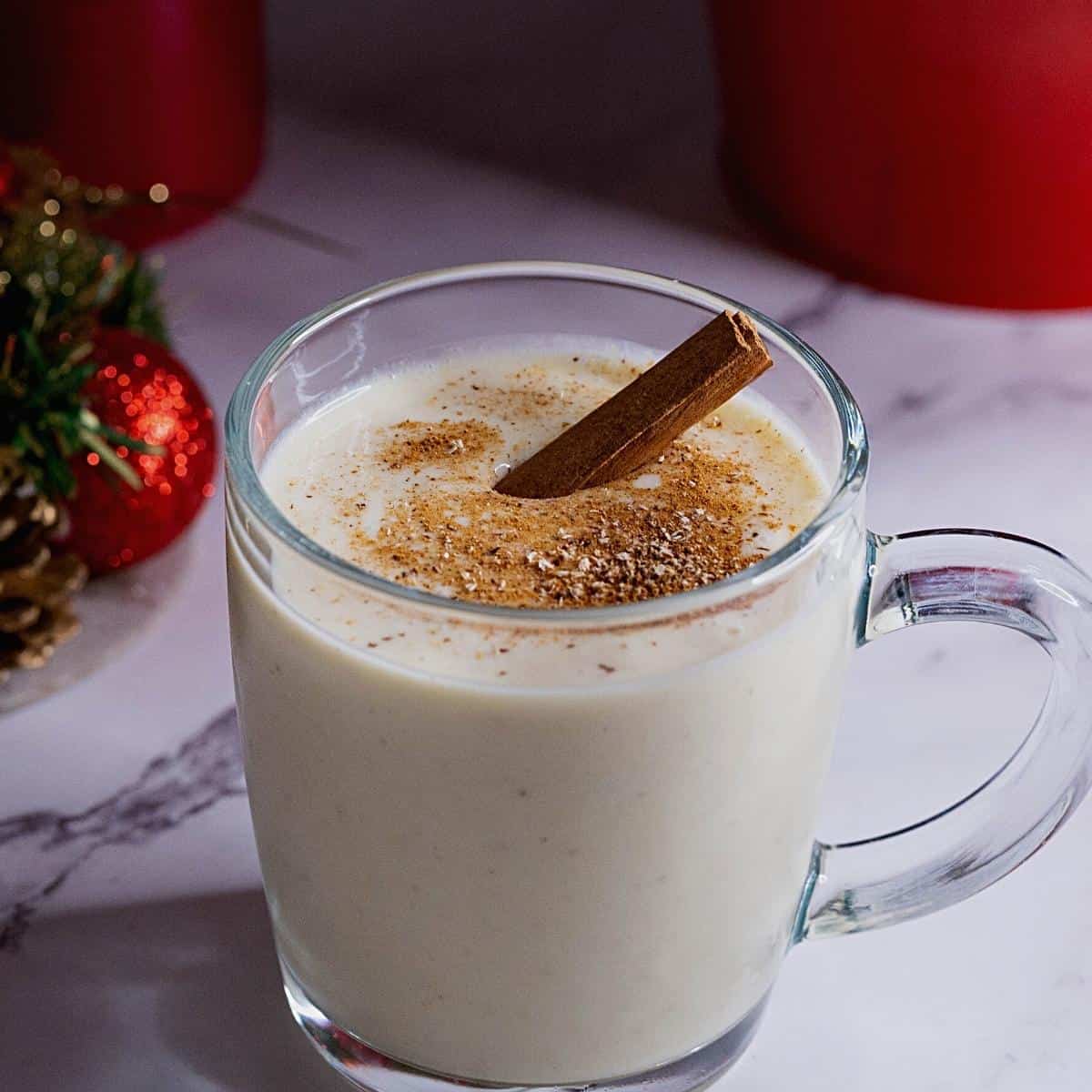 Eggnog is a glass with cinnamon.