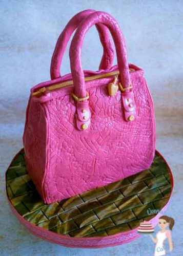 A cake sculpted to look like a pink handbag.