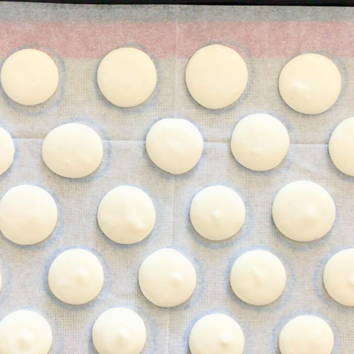 A baking sheet with vanilla macaron batter.