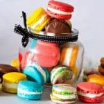 A mason jar with multiple colored macarons.