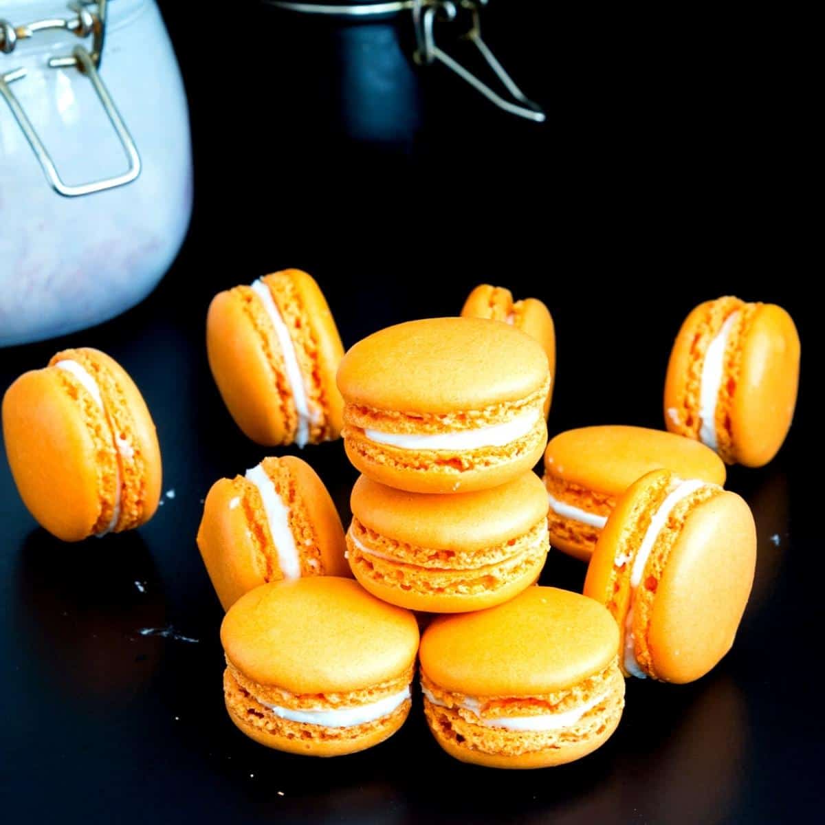 Stack of orange macarons on the table.