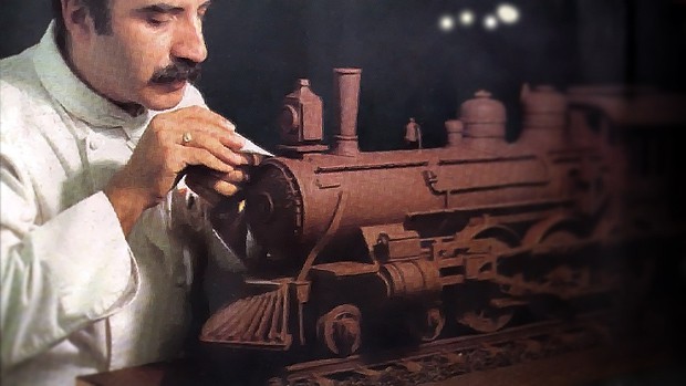 A man decorating a cake like a train.