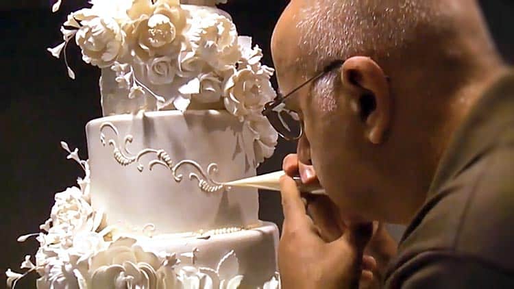 A man decorating a cake.