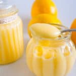 Fresh lemons and jars of fruit curd.