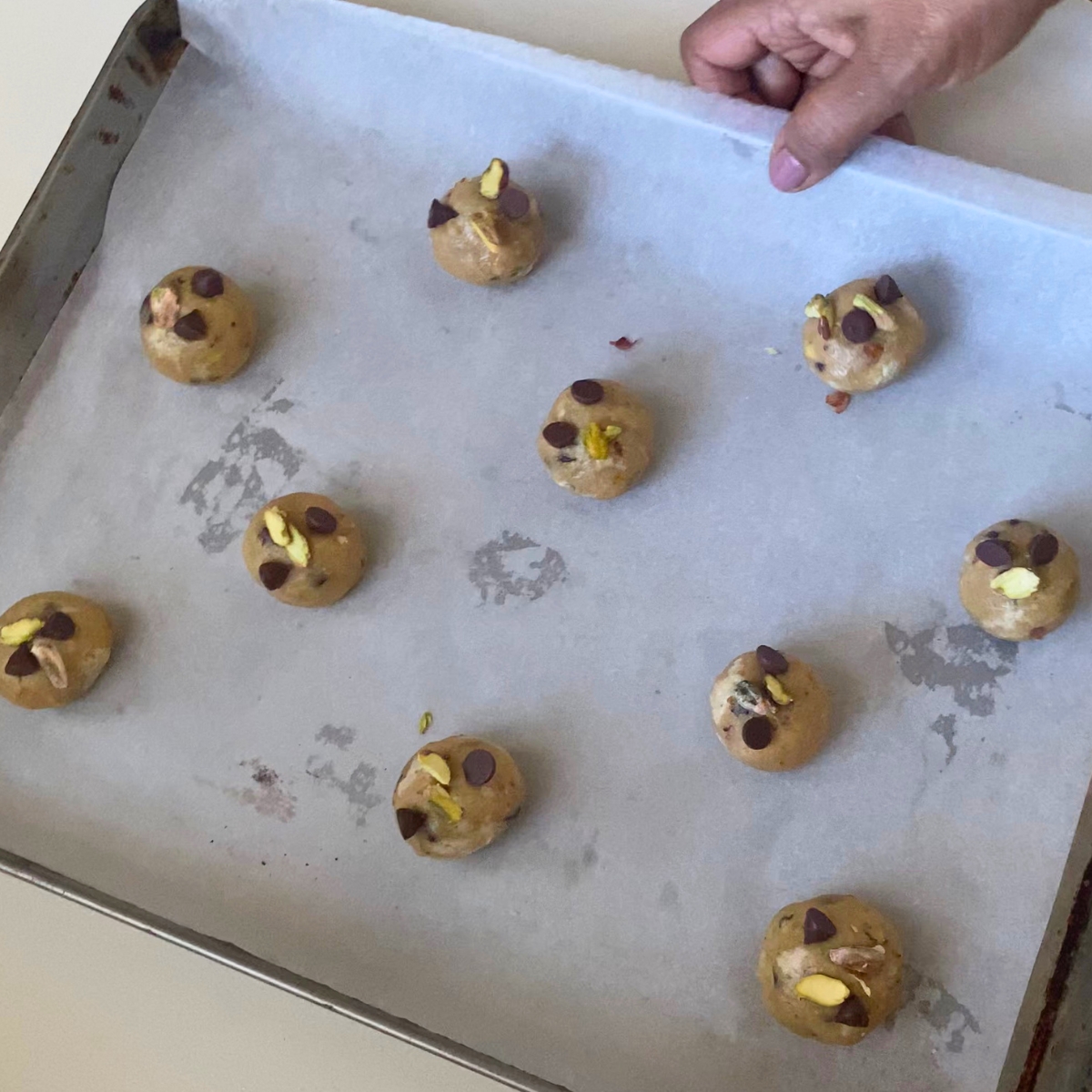 A baking tray with halva cookie dough balls.