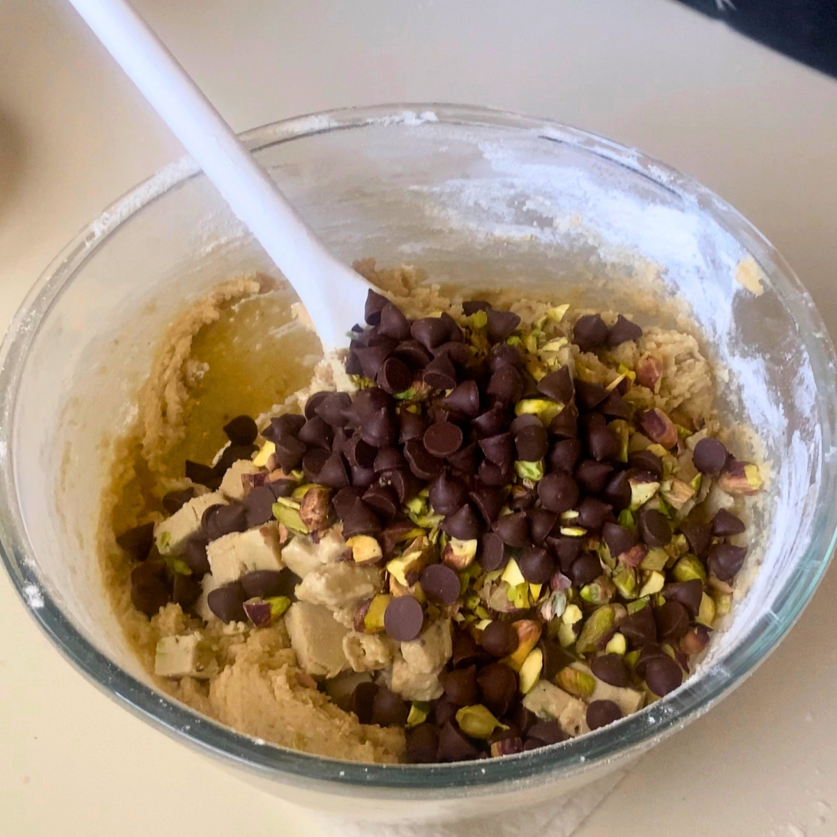 A bowl with cookie dough with halva, pistachio and chocolate chips.