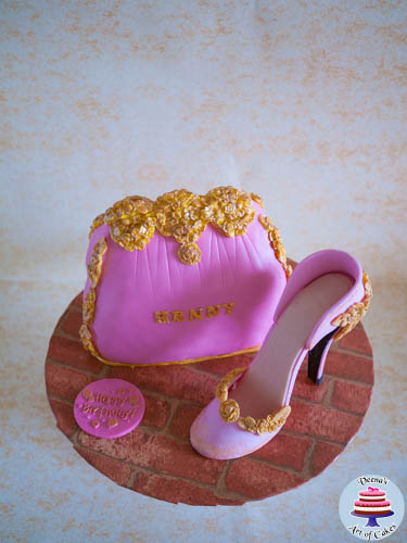 A cake decorated like a lady\'s handbag with a gum paste stiletto.