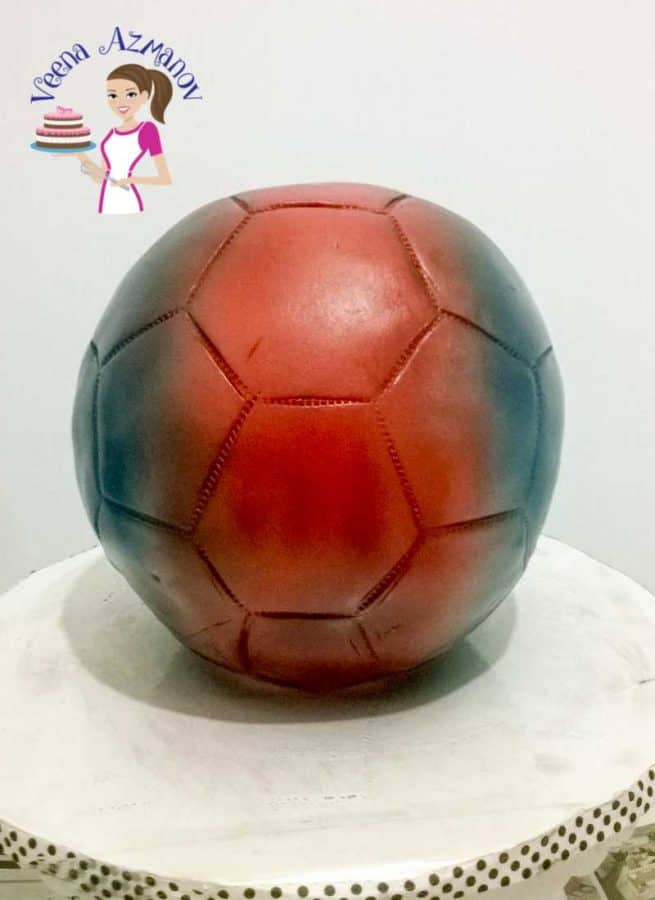 Progress photos of making a cake decorated to look like a Barcelona football.