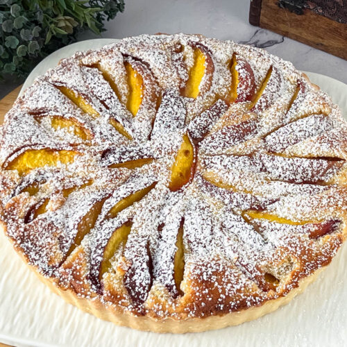 A nectarine tart on the white plate.