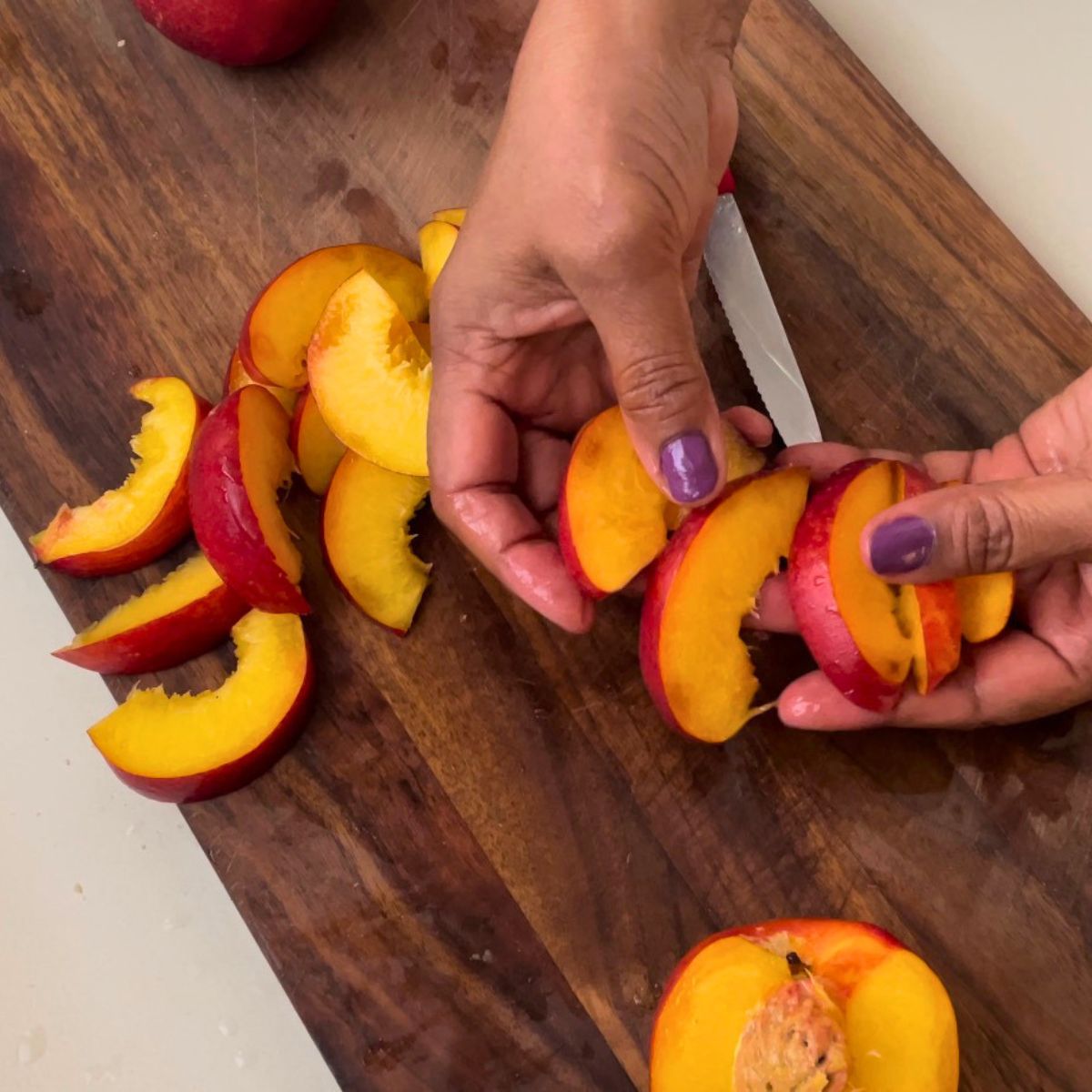 Cutting nectarine slices for nectarine dessert.