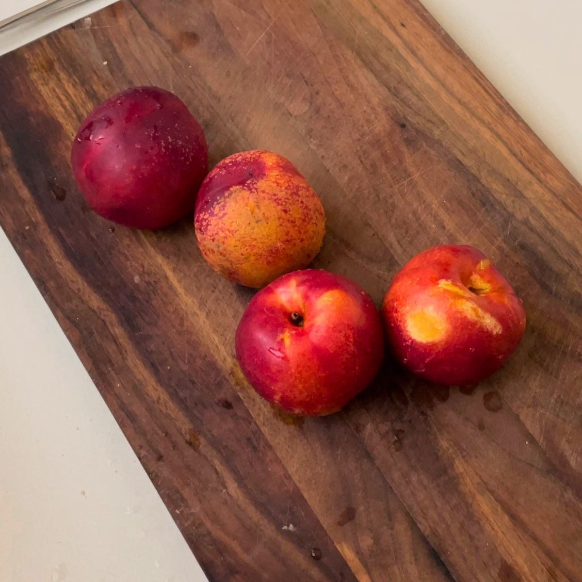 Fresh nectarines on a wooden board.