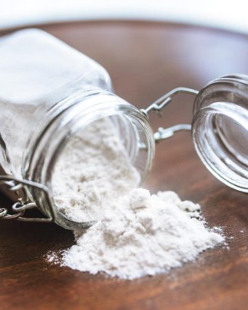 A jar of flour laying on a table.