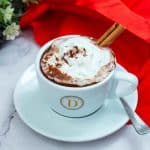 A ceramic cup with hot chocolate and whipped cream.