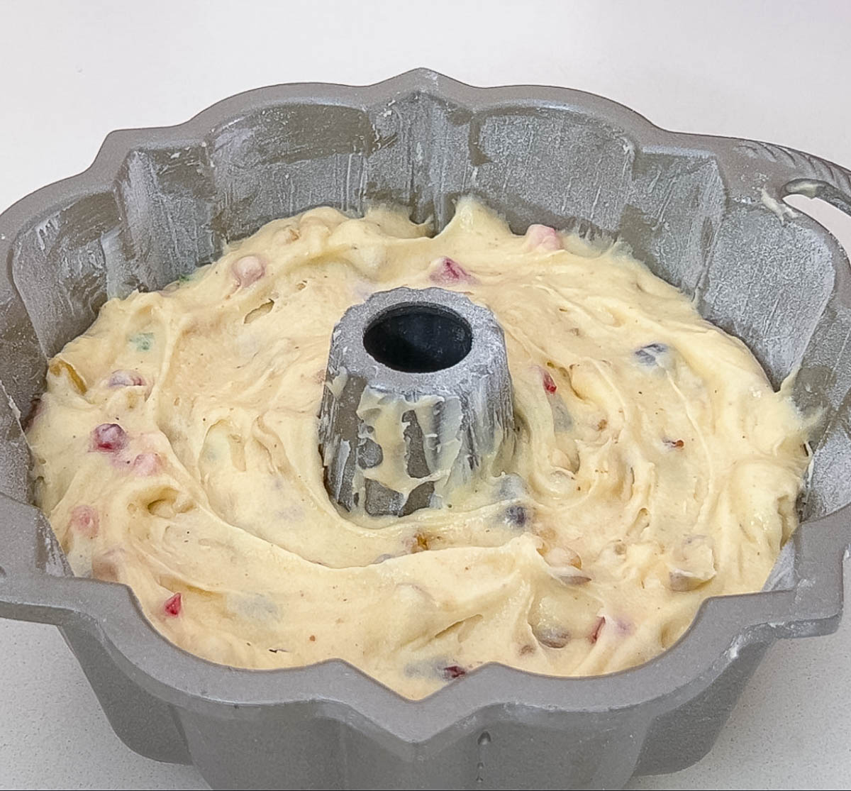 Bundt pan with glace fruit cake batter ready for baking.