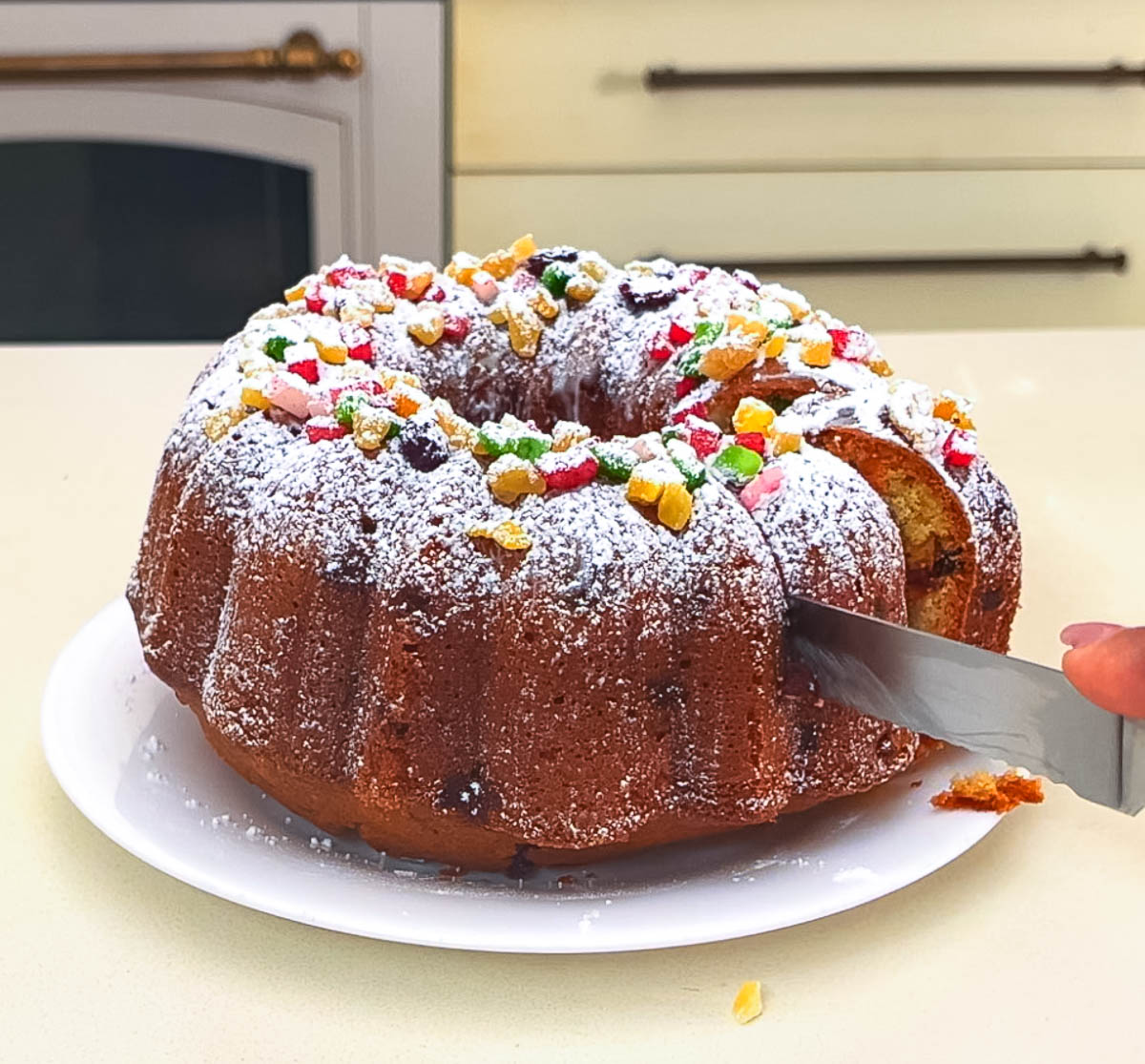 Close-up of a moist fruitcake slice with mixed candied fruit cubes.