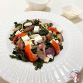 A white plate with kale, feta and olives