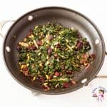 A skillet with kale and pine nuts