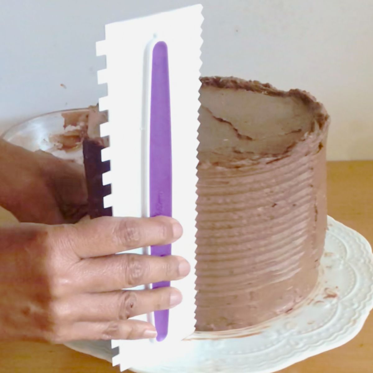 Making a pattern on a classic chocolate cake with bench scraper.