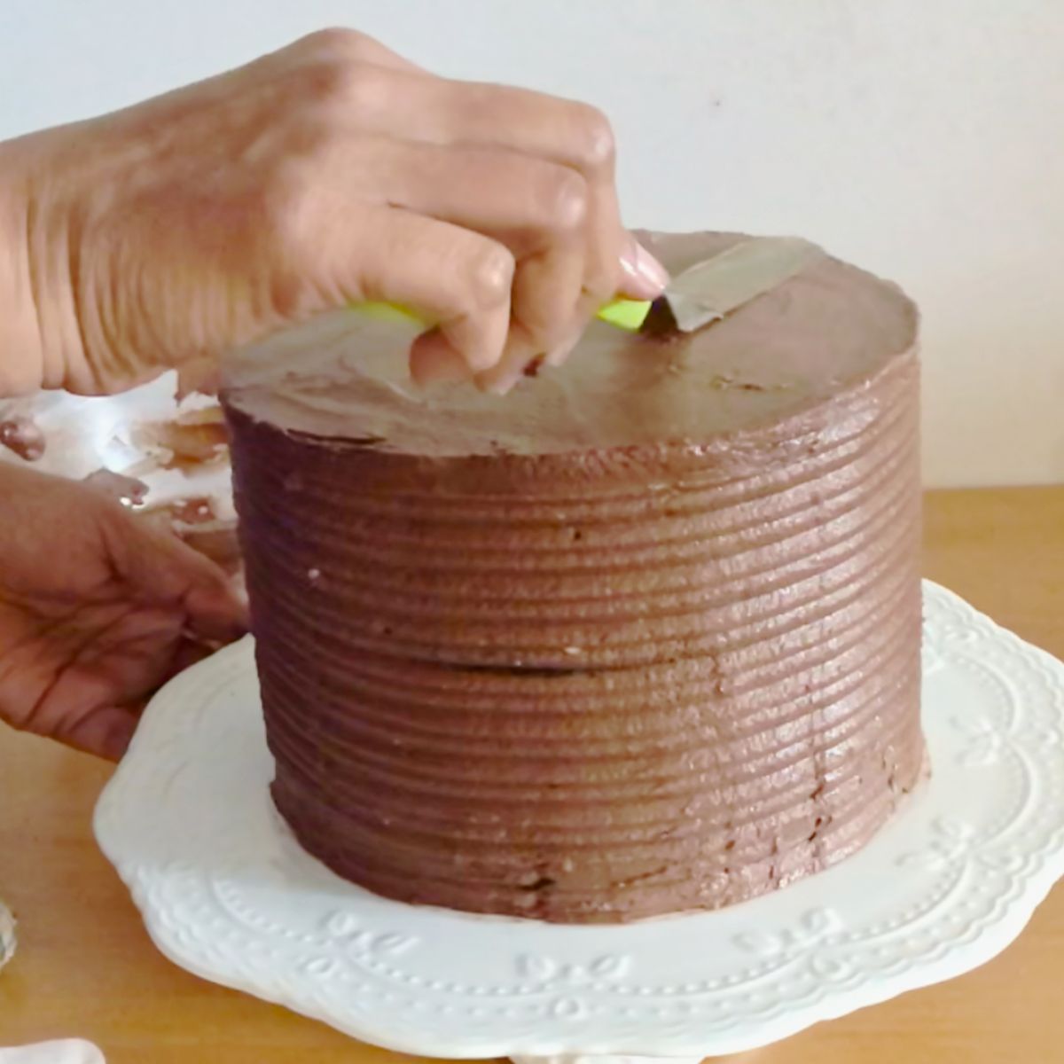 Frosting an 8-inch chocolate cake with SMBC.