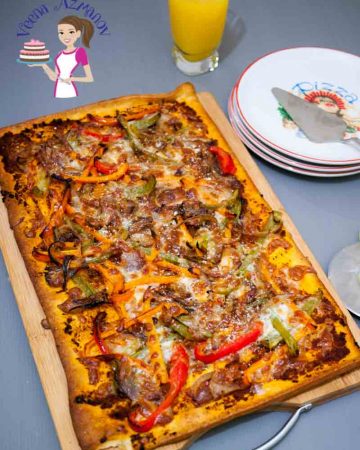 A red pesto pizza with bell peppers.