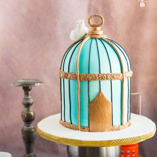 A cake decorated to look like a vintage bird cage.