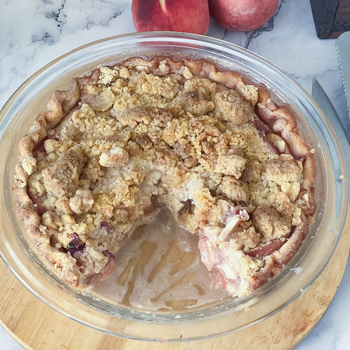A sliced peach pie in a baking dish.