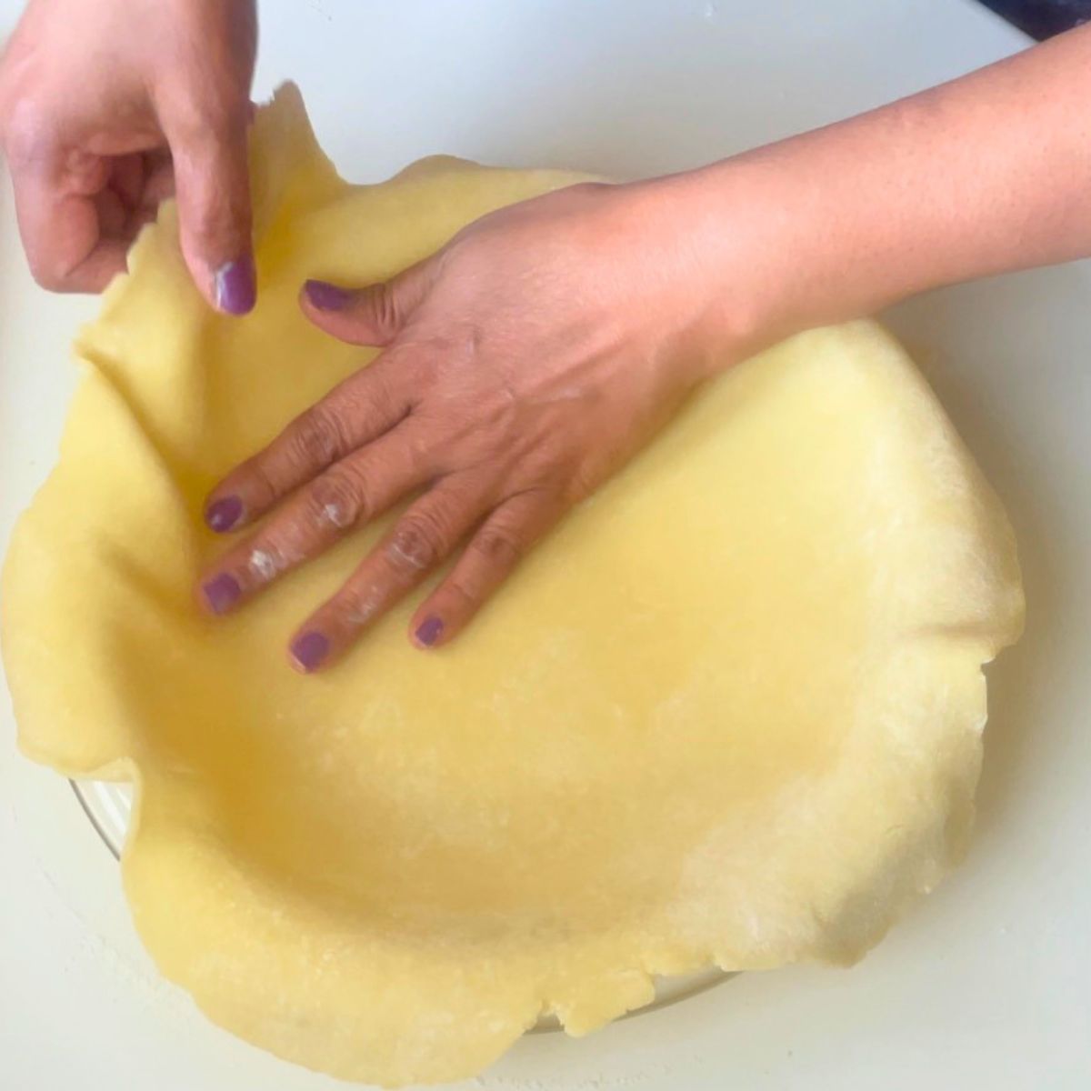 Lining a pie pan with pie dough.