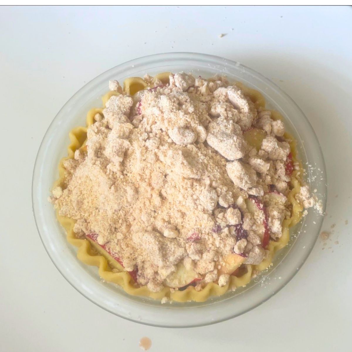 Peach pie topped with crumble for baking.