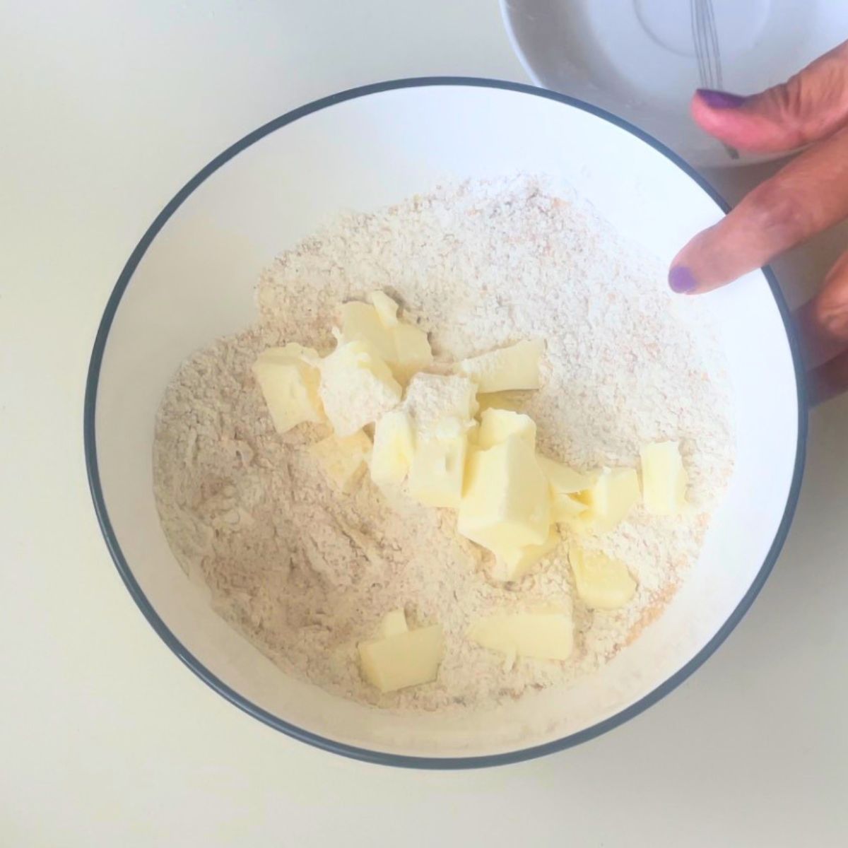 Making crumble in a white bowl.