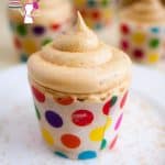 Frosted cupcake on a white plate with brown sugar