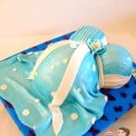 A cake decorated to look like a pregnant belly.