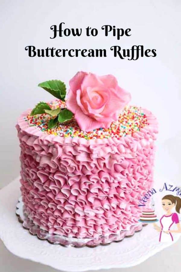 A pink buttercream ruffles cake with a sugar flower on top.