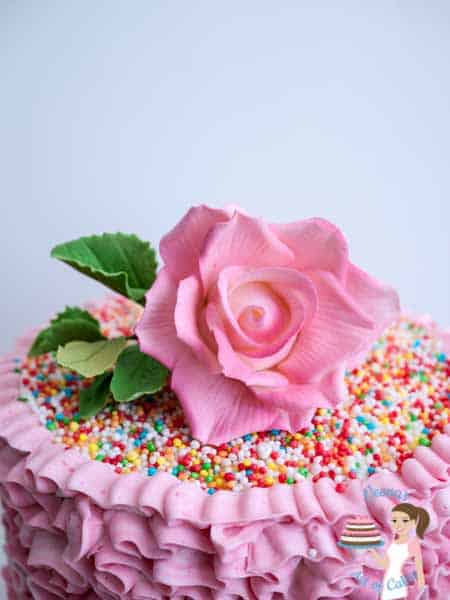 Pink flower on a Buttercream Ruffles Cake. 