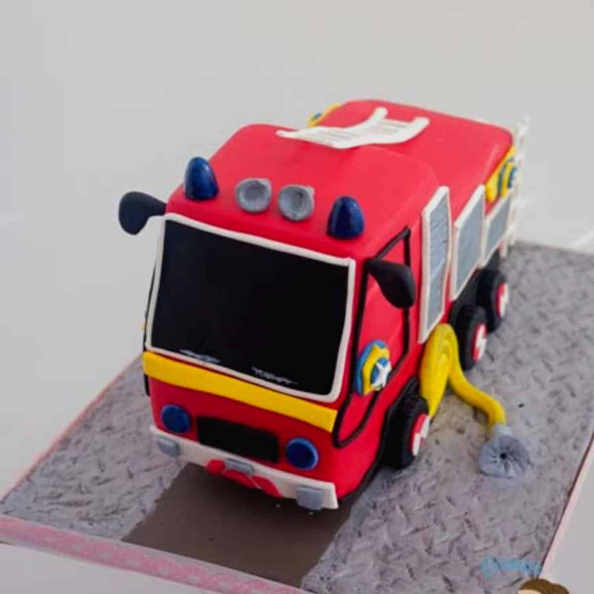 A frosted cake with fire truck cake.