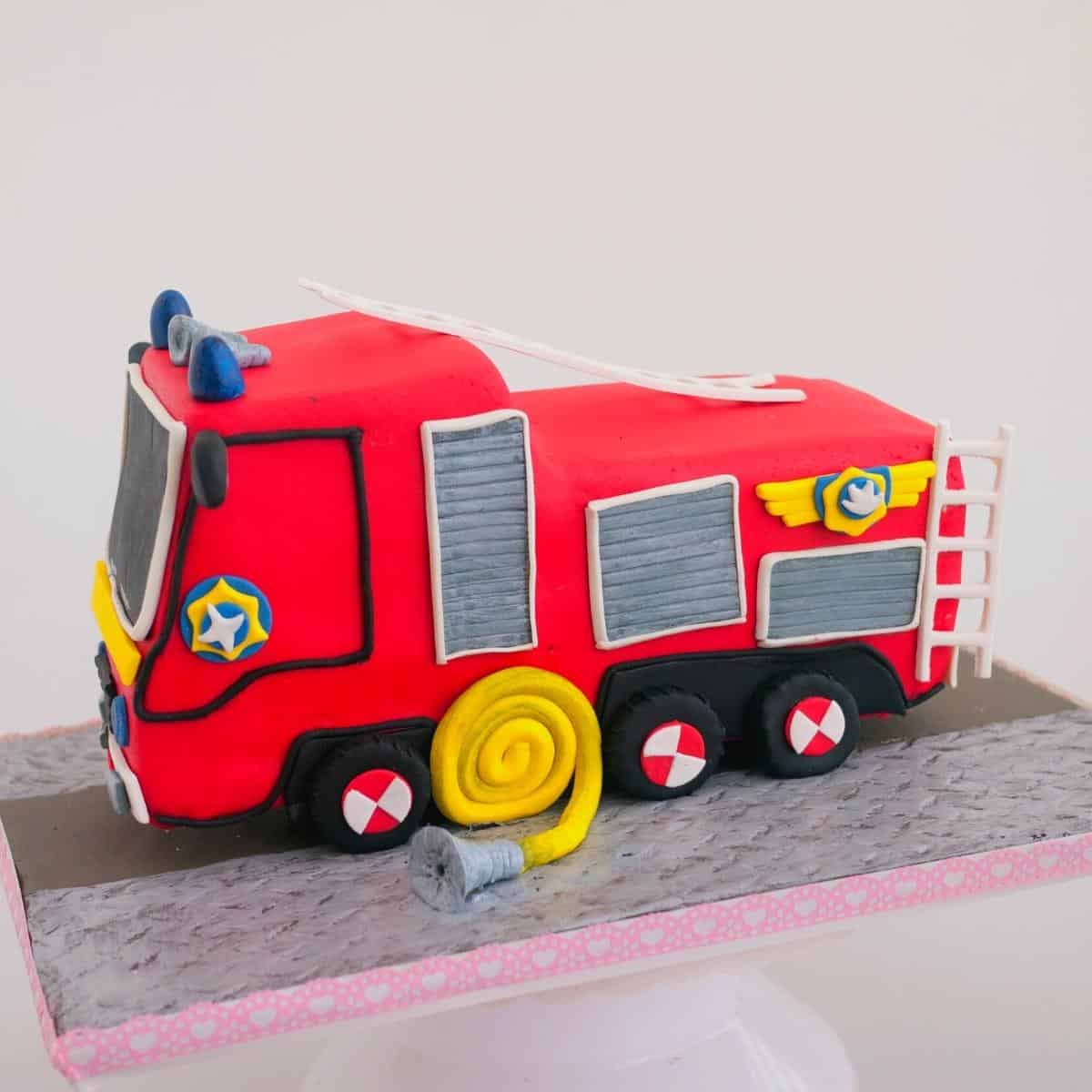 A cake board with fire truck cake in fondant.