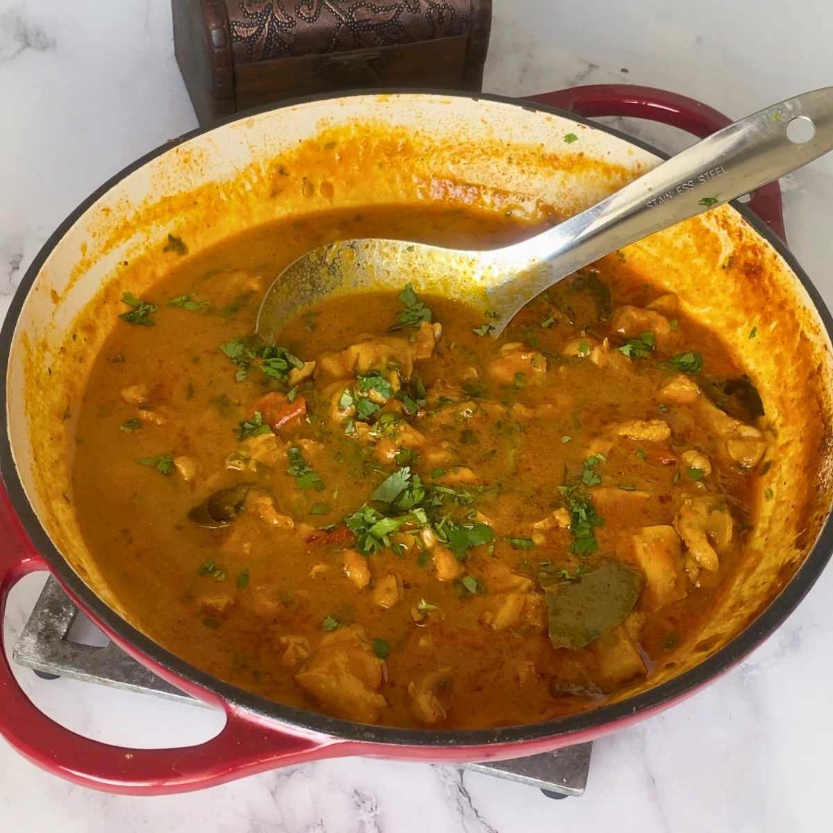 Garnish chicken curry with cilantro.