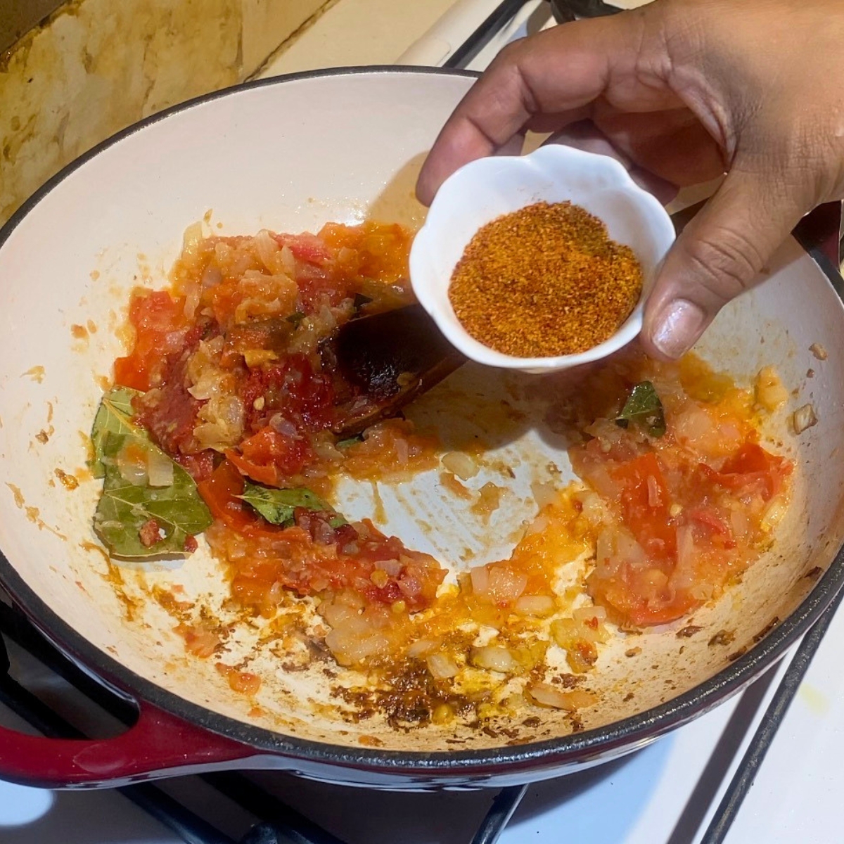Adding curry powder to the onions and aromatics.
