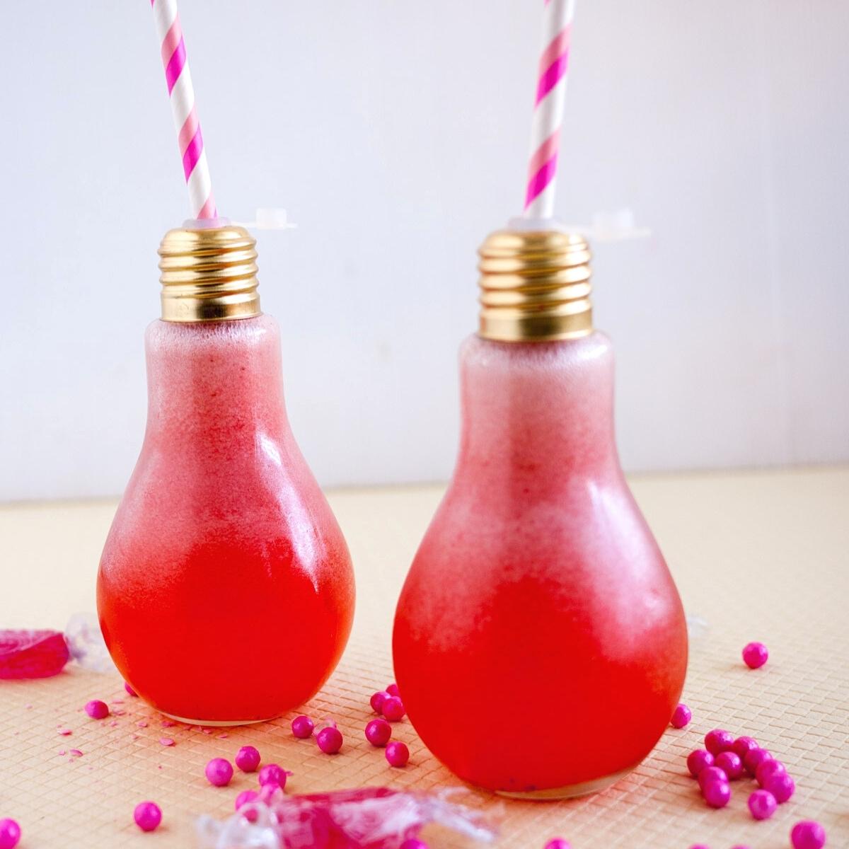 Two lightbulb shaped glasses with strawberry lemonade