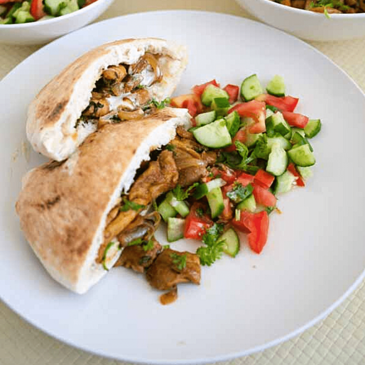 A plate with shawarma and salad with tahinis sauce.