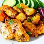 A plate with roasted veggies and paprika chicken.