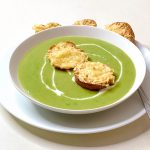 A bowl with fresh green pea soup.