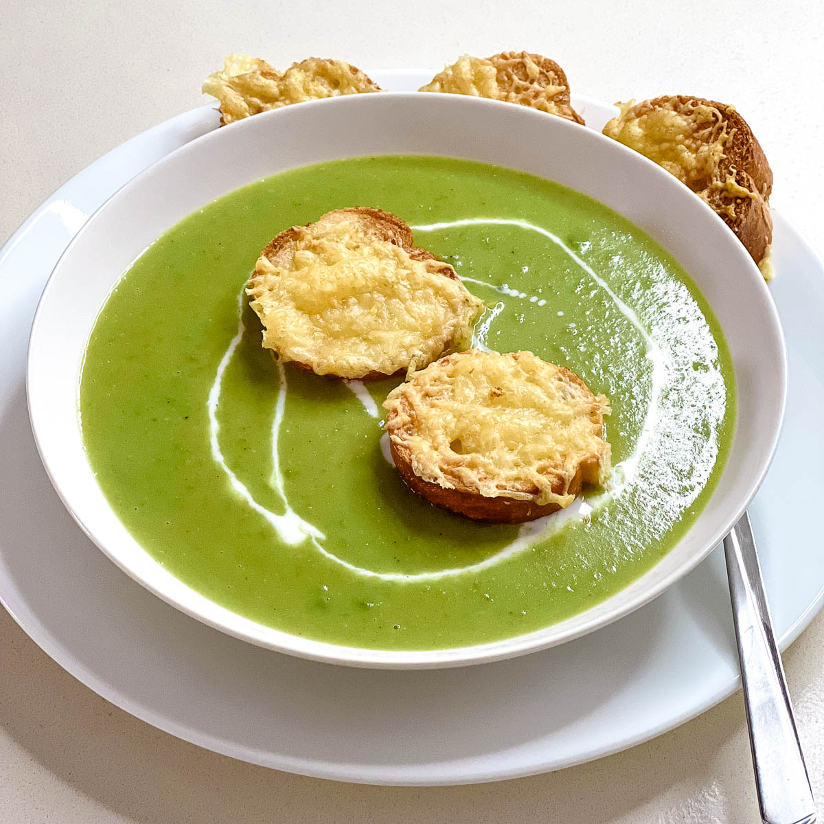 Green pea soup in the bowl with cheese toast.
