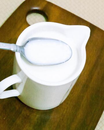A cup of butter milk on the table.