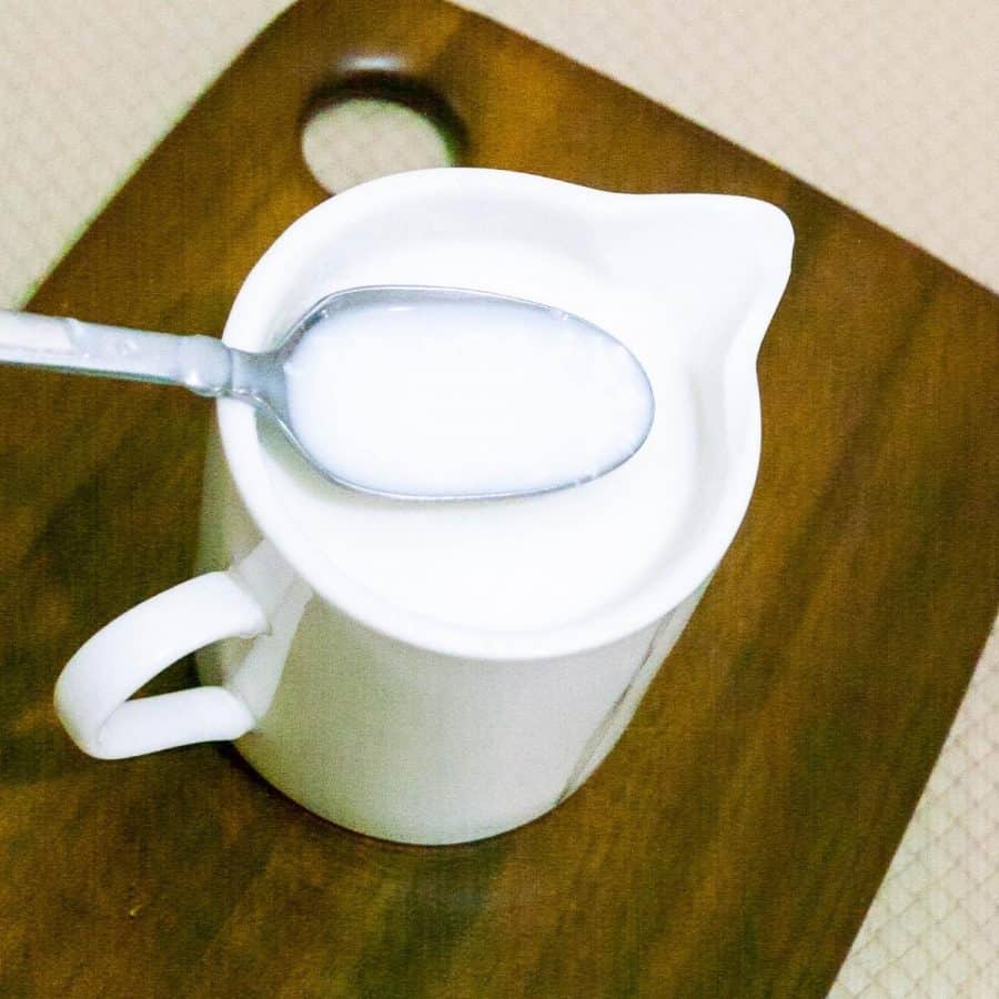 A cup of butter milk on the table.