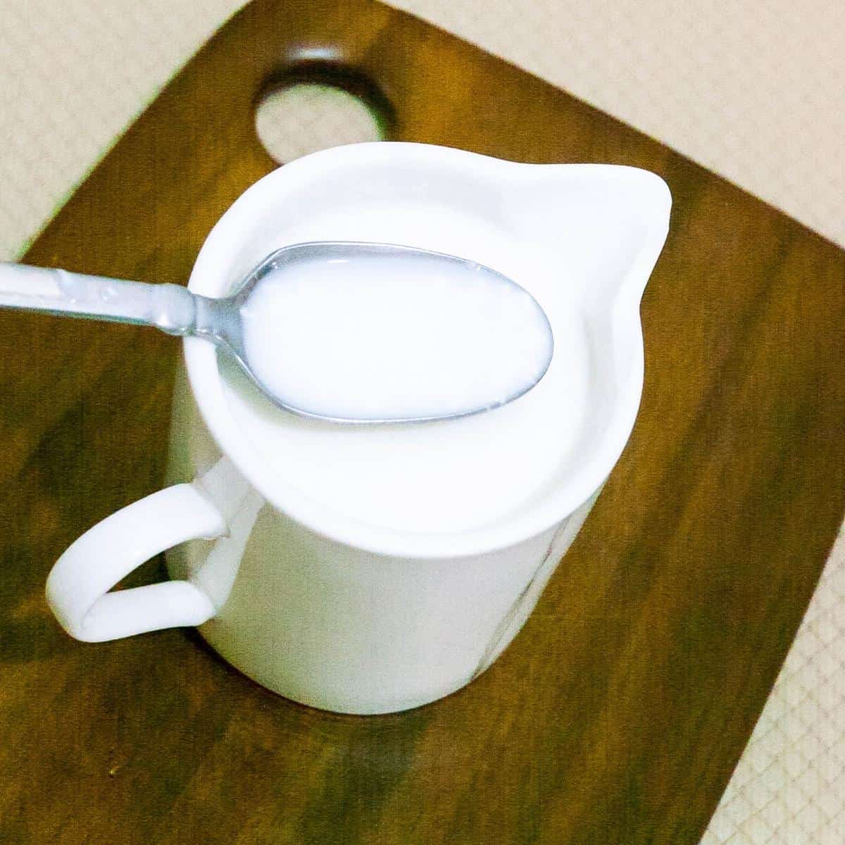 A cup of butter milk on the table.