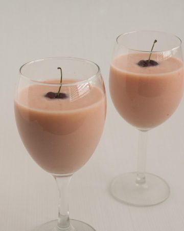 Two wine glasses with cherry eggnog
