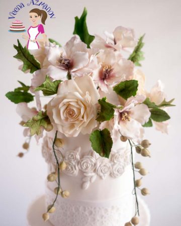 White sugar flowers on top of a wedding cake.