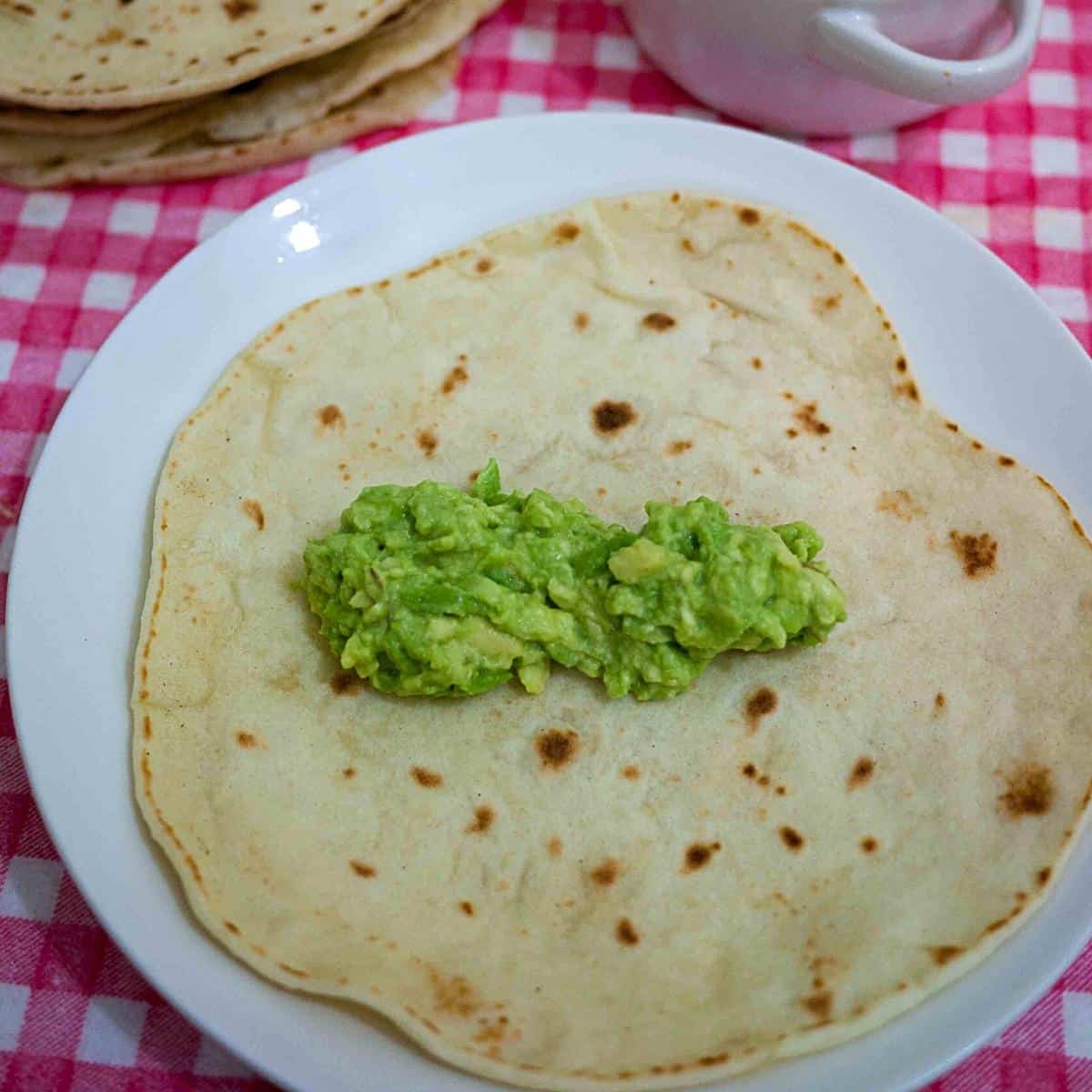 A plate with tortilla and guacamole.